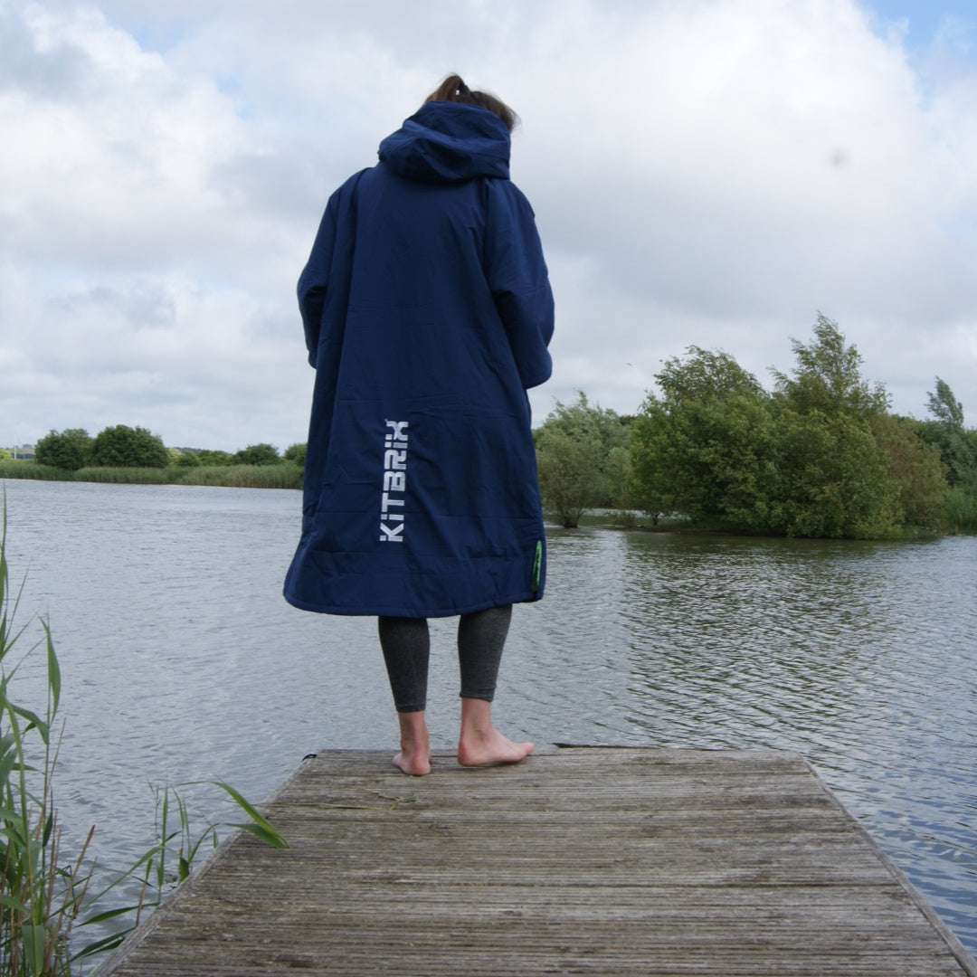 A woman in a poncho by the lakeside