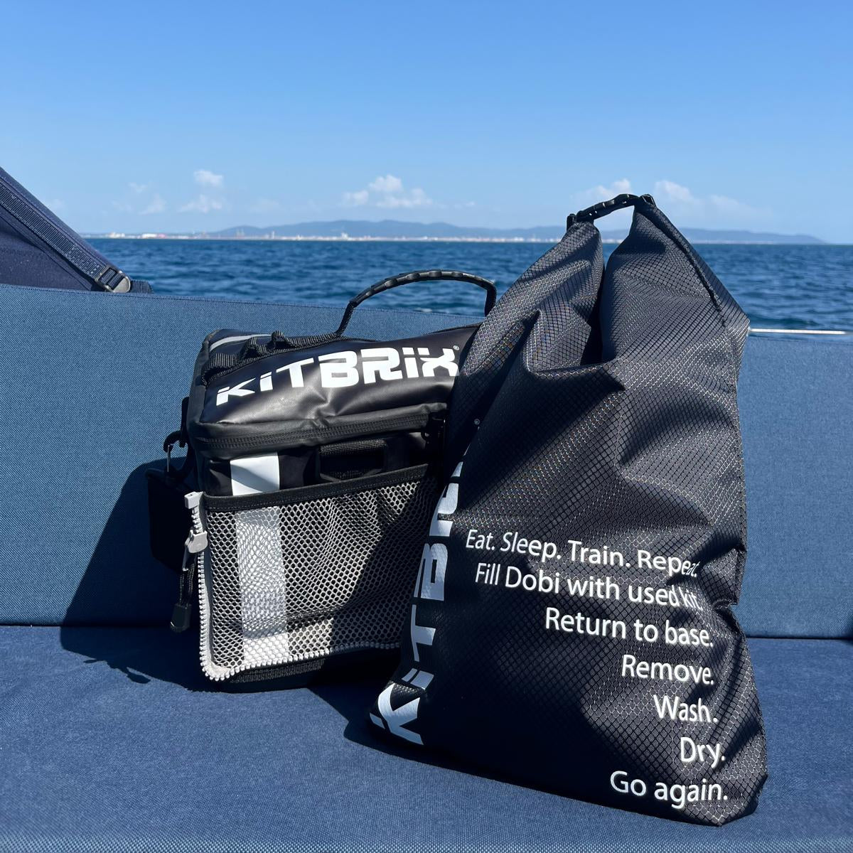 The Dobi dry bag and Hero transistion bags with text on a blue surface with a clear blue sky in the background.