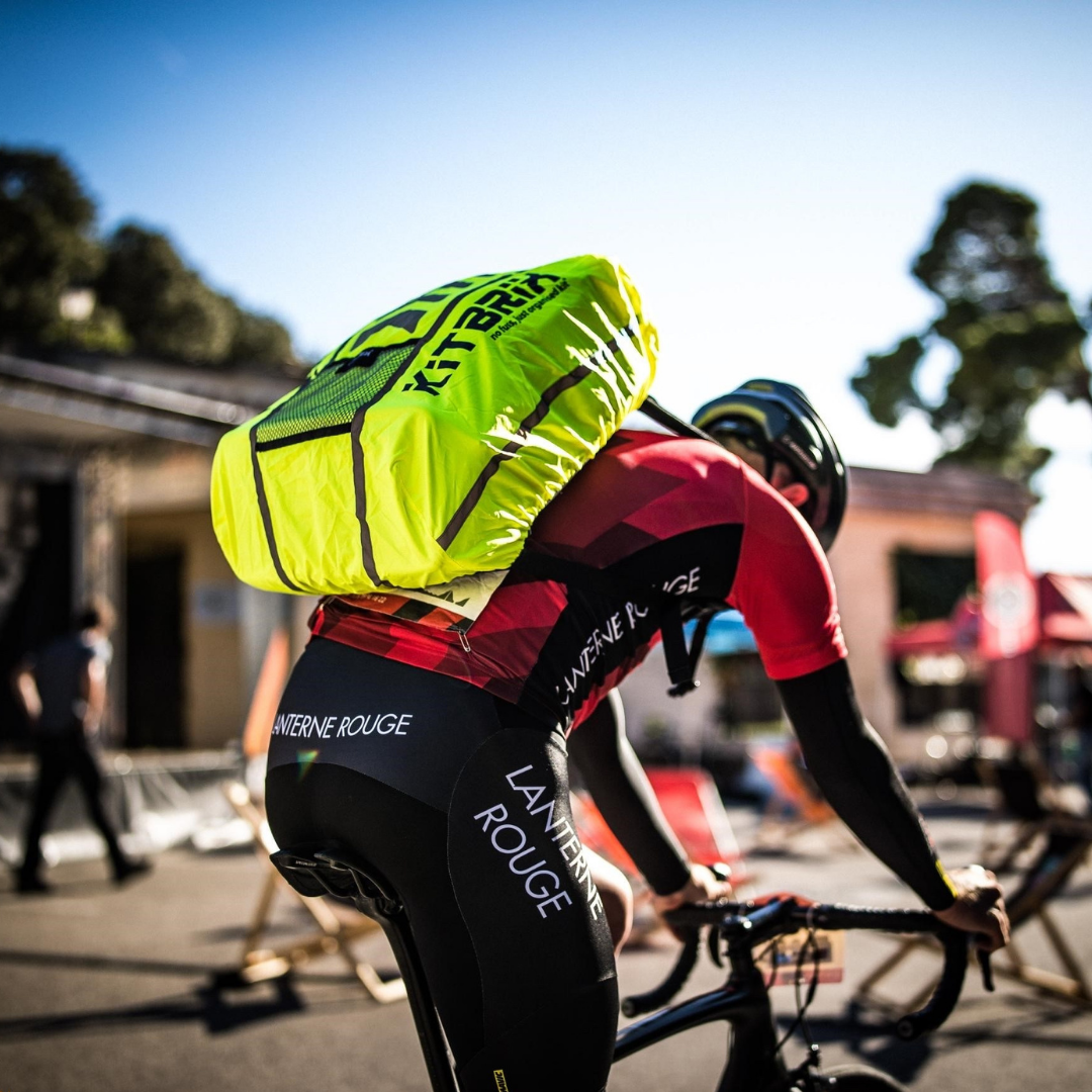 Waterproof rucksack cover on a man’s backpack while cycling in the rain.
